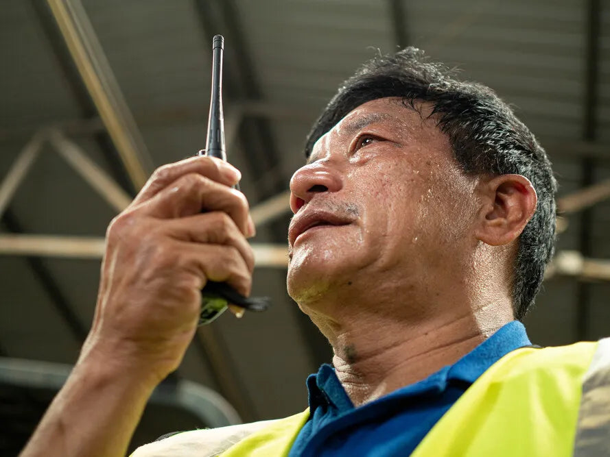 Fotografía de un Hombre de almacén usando uno de los radios de comunicación interna empresarial