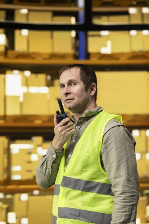 Foto de un hombre de almacén usando uno de los radios para logística y distribución que brinda COMREGIO