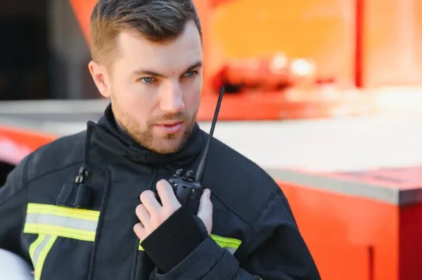 Fotografía a un hombre que trabaja en protección civil usando uno de los radios de comunicación de COMREGIO
