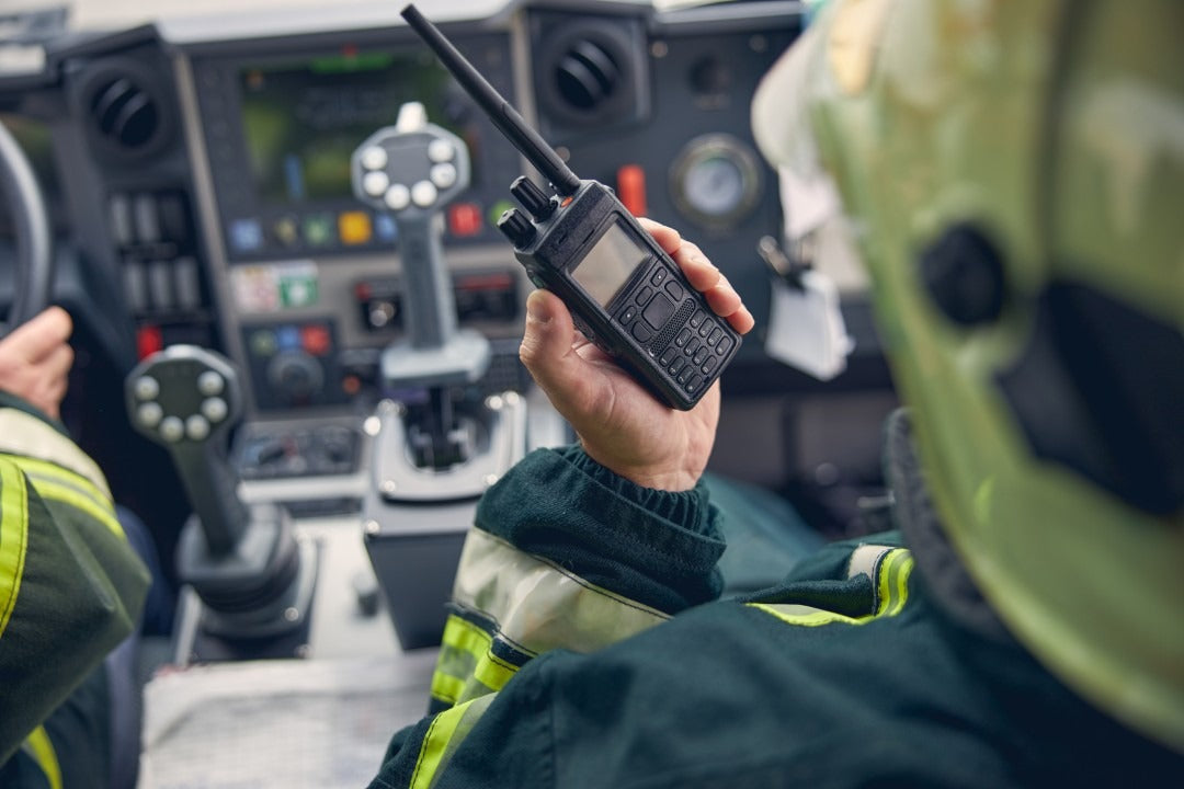 Fotografía de un Hombre que va de copiloto utilizando un radio PTT de COMREGIO para comunicarse