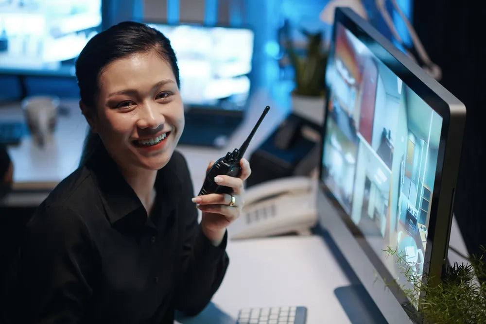 Fotografía de una Mujer en su oficina utilizando uno de los radios para operaciones industriales de COMREGIO 