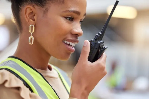  Fotografía de una mujer encargada de obra utilizando uno de los radios Motorola de COMREGIO
