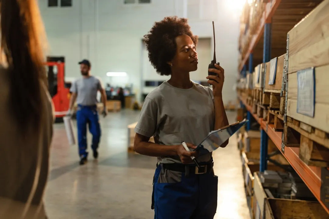 Fotografía de una mujer usando uno de los radios para almacenes y logística haciendo inventario